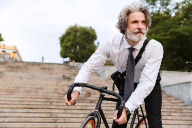 Yakışıklı, kendine güvenen, sakallı, takım elbiseli adam.