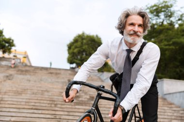 Yakışıklı, kendine güvenen, sakallı, takım elbiseli adam.