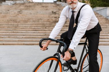 Yakışıklı, kendine güvenen, sakallı, takım elbiseli adam.