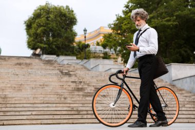 Yakışıklı, kendine güvenen, sakallı, takım elbiseli adam.