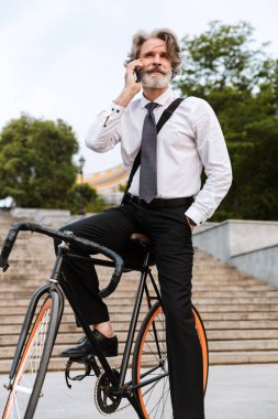 Yakışıklı, kendine güvenen, sakallı, takım elbiseli adam.