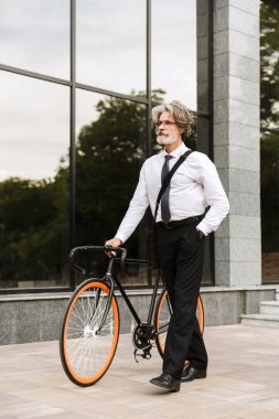 Yakışıklı, kendine güvenen, sakallı, takım elbiseli adam.