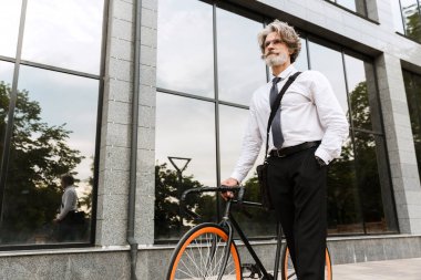 Yakışıklı, kendine güvenen, sakallı, takım elbiseli adam.