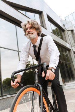 Yakışıklı, kendine güvenen, sakallı, takım elbiseli adam.