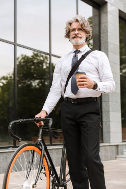 Yakışıklı, kendine güvenen, sakallı, takım elbiseli adam.