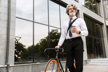 Yakışıklı, kendine güvenen, sakallı, takım elbiseli adam.