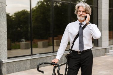 Yakışıklı, kendine güvenen, sakallı, takım elbiseli adam.