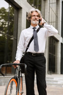 Yakışıklı, kendine güvenen, sakallı, takım elbiseli adam.