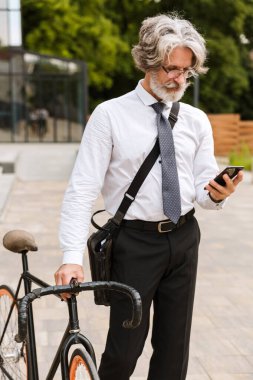 Yakışıklı, kendine güvenen, sakallı, takım elbiseli adam.