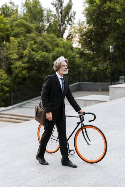 Yakışıklı, kendine güvenen, sakallı, takım elbiseli adam.