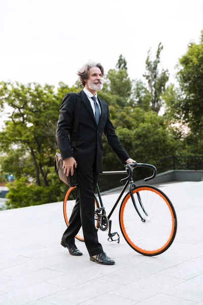 Yakışıklı, kendine güvenen, sakallı, takım elbiseli adam.