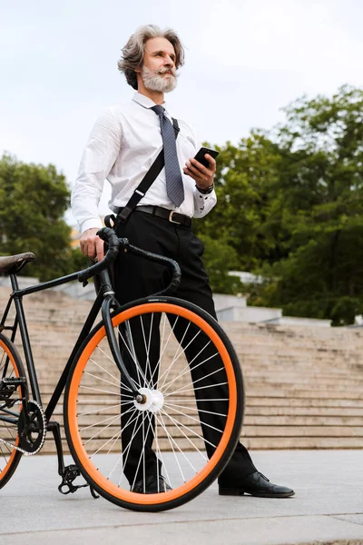 Yakışıklı, kendine güvenen, sakallı, takım elbiseli adam.