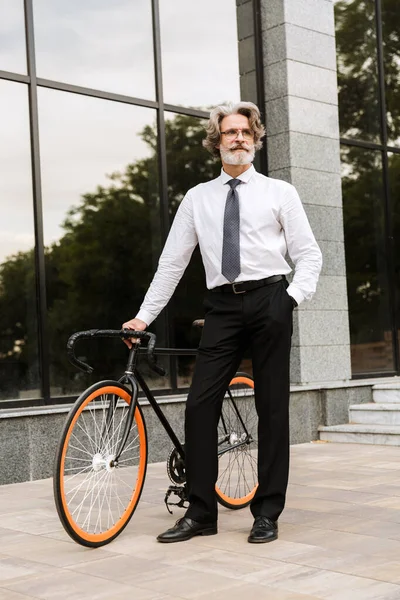 Yakışıklı, kendine güvenen, sakallı, takım elbiseli adam.