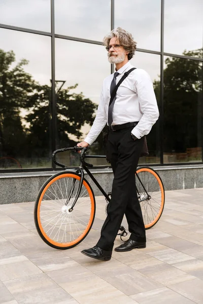 Yakışıklı, kendine güvenen, sakallı, takım elbiseli adam.