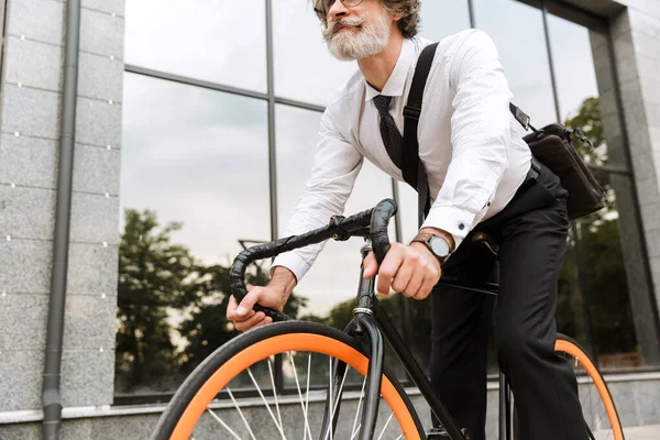 Yakışıklı, kendine güvenen, sakallı, takım elbiseli adam.