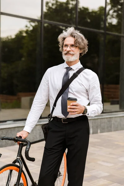 Yakışıklı, kendine güvenen, sakallı, takım elbiseli adam.