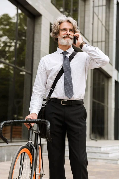 Yakışıklı, kendine güvenen, sakallı, takım elbiseli adam.