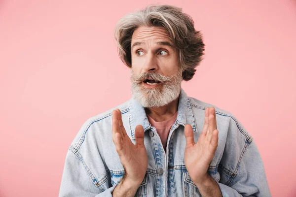 Porträt eines erstaunten alten Mannes mit grauem Bart, der mit erhobenen Händen zur Seite schaut — Stockfoto
