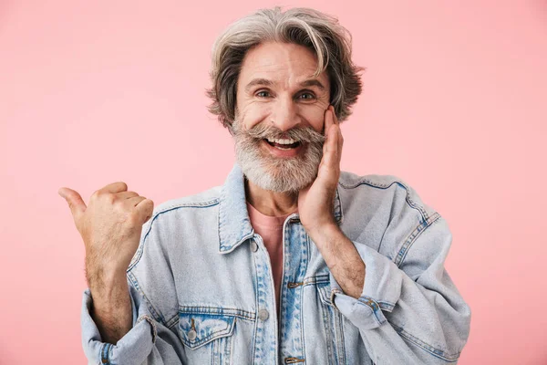 Portrait of joyful old man with gray beard laughing and pointing