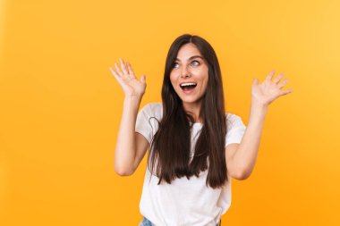 Image of excited brunette woman with long hair laughing and rais
