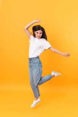 Uzun saçlı, gülümseyen, çekici esmer kadının tam boy görüntüsü.