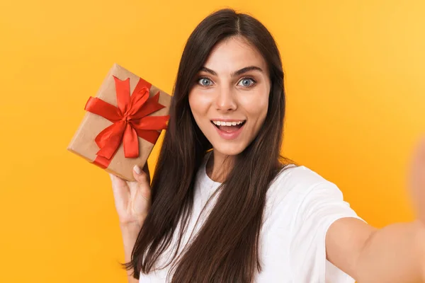 Obrázek krásné brunetky žena s dlouhými vlasy držení dárek — Stock fotografie