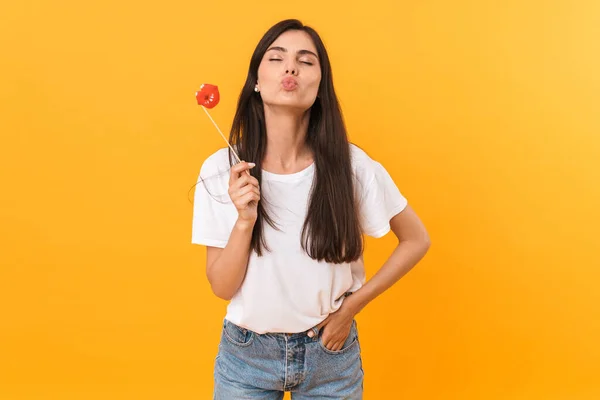 Image of charming brunette woman wearing basic clothes kissing a — 스톡 사진