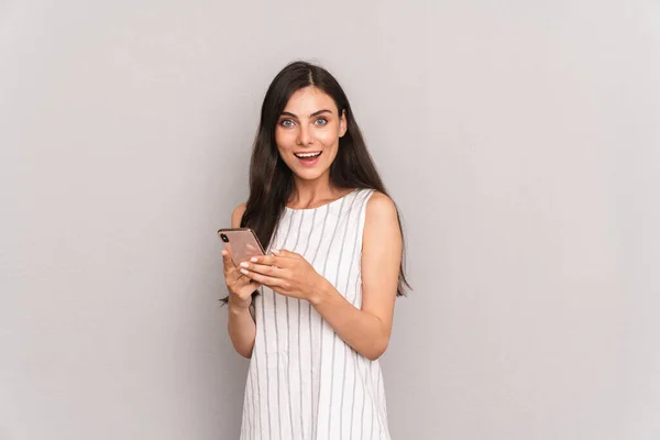 Imagem de mulher morena alegre vestindo vestido sorrindo enquanto hol — Fotografia de Stock