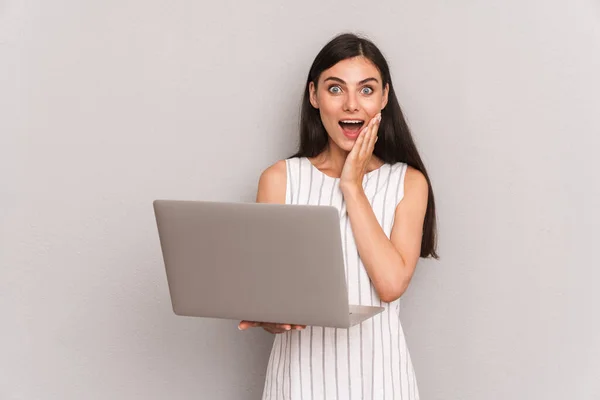 Imagem de mulher morena excitada usando vestido sorrindo enquanto segura — Fotografia de Stock