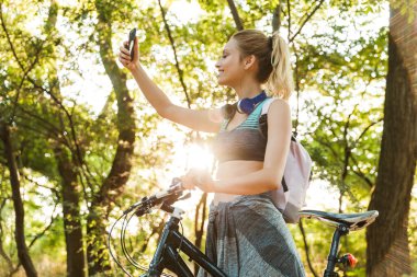 Neşeli genç fitness kızı sırt çantası taşıyor.