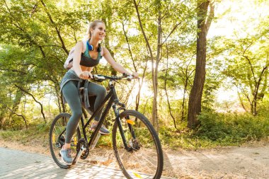 Neşeli genç fitness kızı sırt çantası taşıyor.