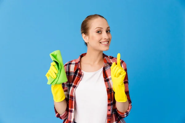 Portrait of cheerful housewife in yellow rubber gloves holding d — Stock Photo, Image
