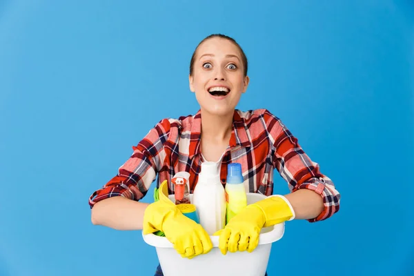 Portrait of joyful housewife in rubber gloves holding basin with — Stock Photo, Image