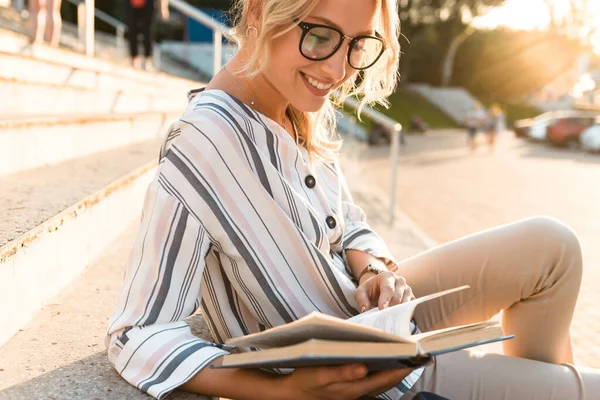 Lächelnde junge Frau liest Buch — Stockfoto