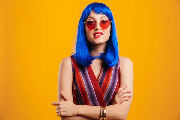 Porträtt av söt förförisk kvinna bär blå peruk och solglasögon tittar på kameran och biter läppen — Stockfoto