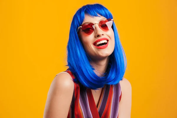 Porträtt av rolig kaukasiska kvinna bär blå peruk och solglasögon tittar på kameran och skrattar — Stockfoto