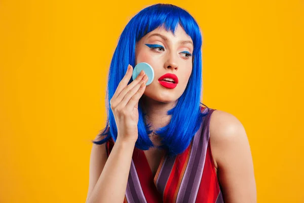 Porträtt av förförisk lockande kvinna bär blå peruk tittar åt sidan och använder pulver svamp — Stockfoto