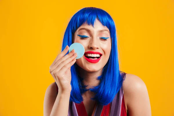 Porträtt av rolig lockande kvinna bär blå peruk skrattar och använder pulversvamp — Stockfoto