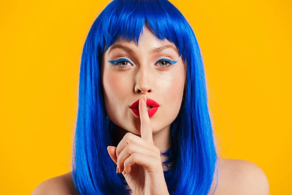 Retrato close-up de sedutora mulher bonito vestindo peruca azul olhando para a câmera e sinal de silêncio gestual — Fotografia de Stock