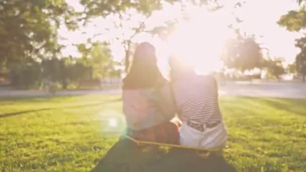 Вид Ззаду Молодих Дівчат Друзі Відпочивають Сидячи Скейтборді Парку — стокове відео