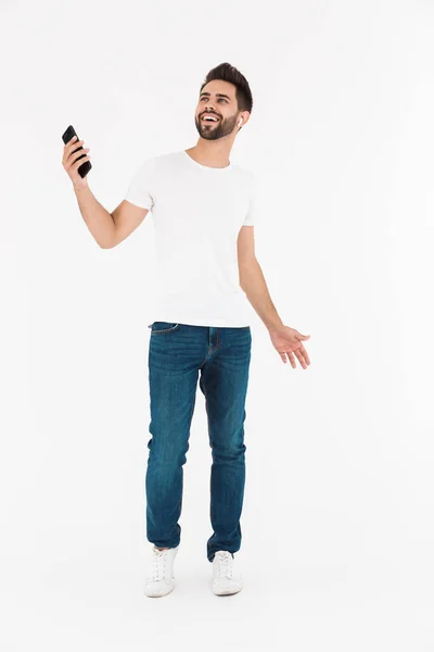 Full length image of happy smiling man listening music on cellphone and earpod while dancing — Stock Photo, Image