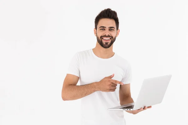 Imagem do homem não barbeado satisfeito segurando e apontando o dedo para laptop — Fotografia de Stock