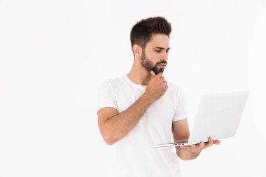 Tıraşsız düşünen bir adamın dizüstü bilgisayara bakıp...