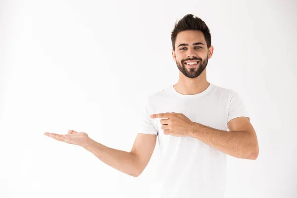 Immagine di attraente uomo sorridente che tiene e punta il dito contro il copyspace — Foto Stock