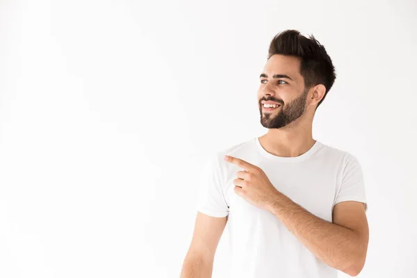 Imagen del joven feliz sonriendo y señalando con el dedo a un lado en el copyspace — Foto de Stock