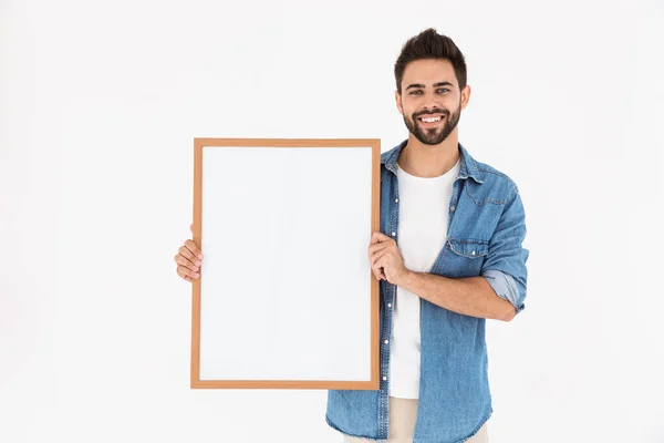 Image d'un jeune homme barbu tenant une pancarte vide dans un cadre pour copier du texte et sourire — Photo