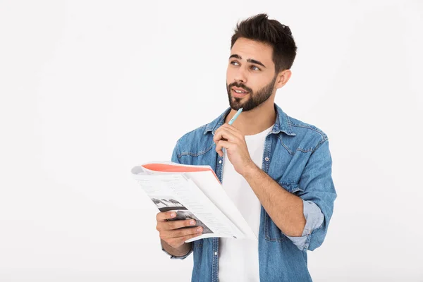 Immagine di un uomo barbuto serio che scrive nel quaderno mentre guarda da parte — Foto Stock