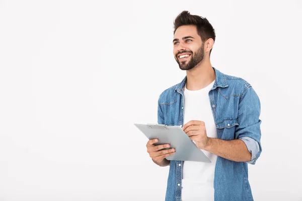 Image of handsome cheerful man holding clipboard and writing while smiling — Stock Photo, Image