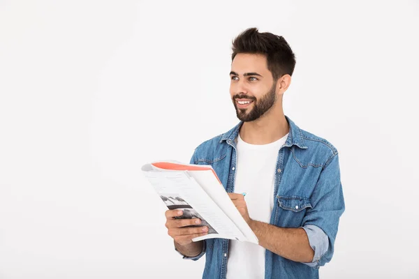 Imagem de homem barbudo alegre escrevendo em caderno de exercícios e sorrindo enquanto olha para o lado — Fotografia de Stock