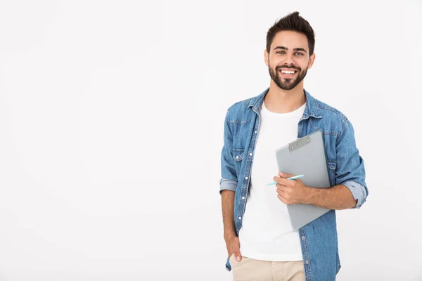 Imagem de jovem alegre segurando prancheta e sorrindo enquanto olha para a câmera — Fotografia de Stock